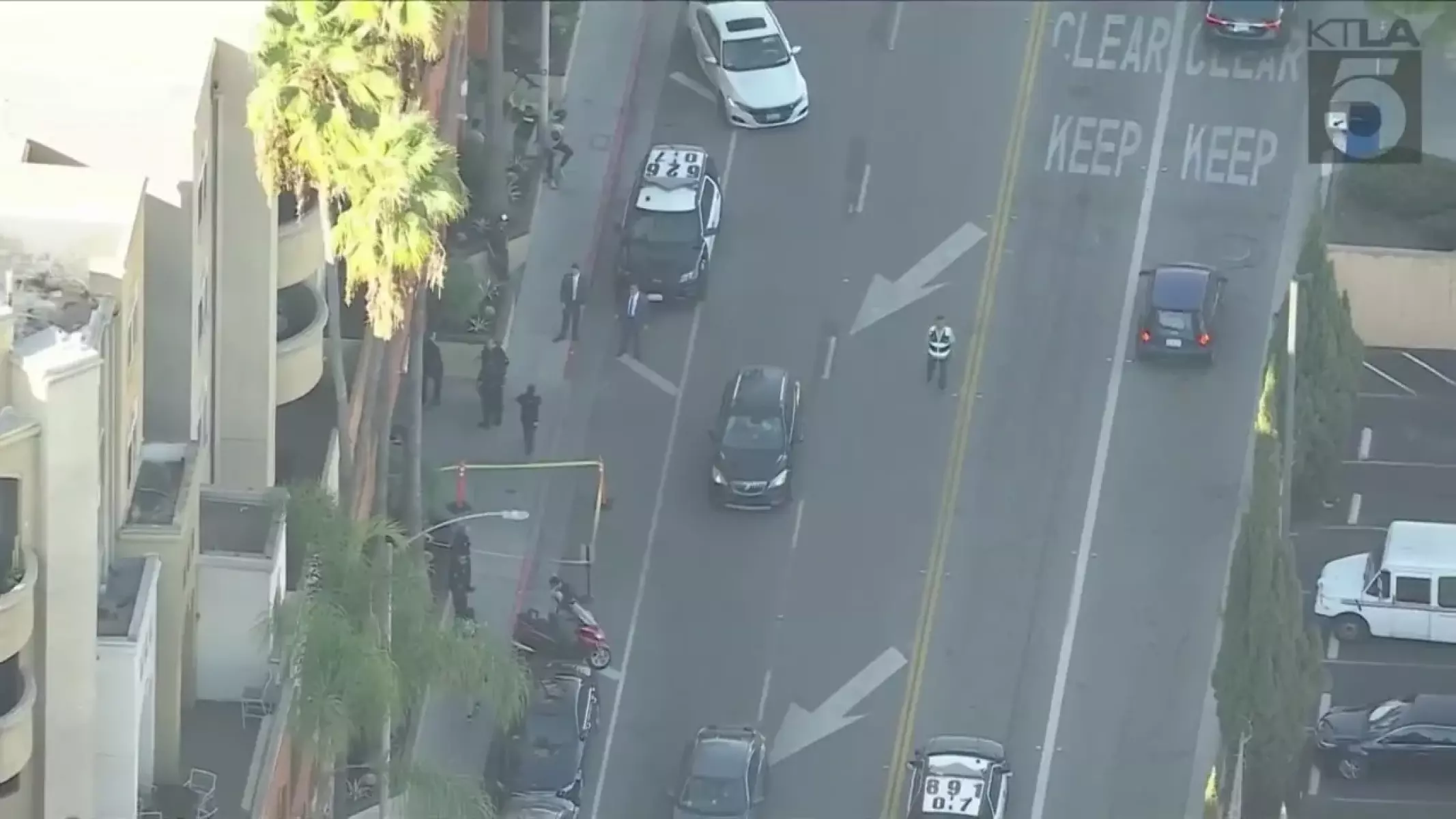 A view from above of police cars and officers on a city street corner.